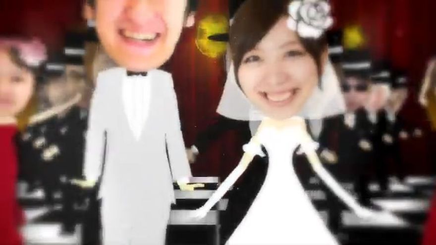 チェス盤のような床の上で、新郎新婦のアバターが写真を持っているシーン