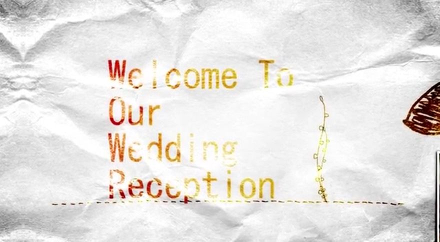 白背景にゴールドの手書き風文字で「Welcome To Our Wedding Reception」と描かれたシーン