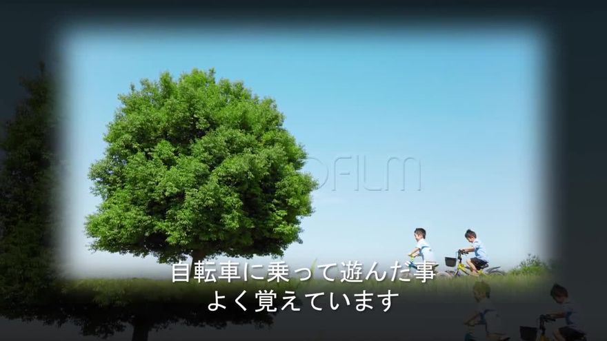 黒い背景に白くにじむグローの縁取りで大きな木と自転車に乗る子どもの写真を映し前後の写真がうっすら重なり下に白い字幕を添えたシーン